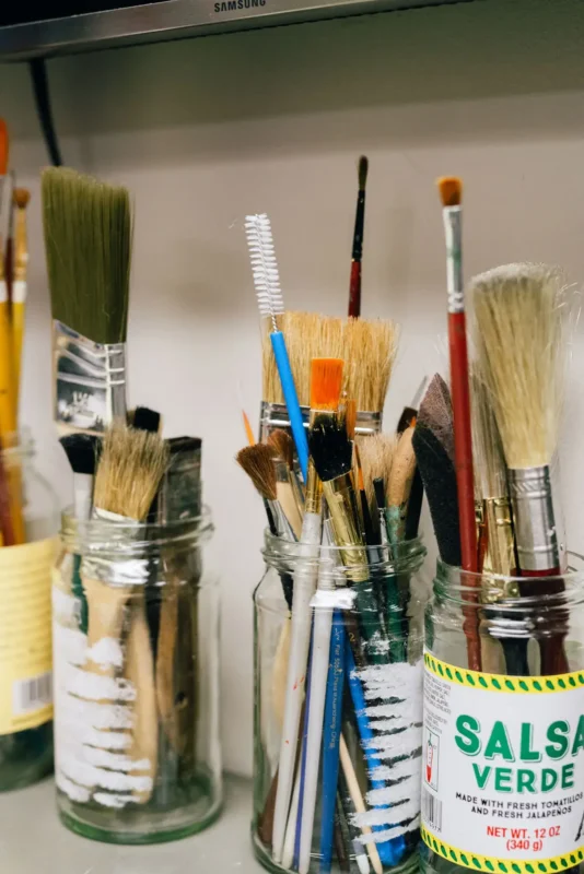 Jars of differently sized and shaped paintbrushes