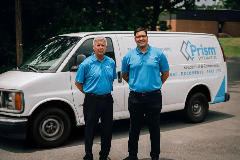 Two Prism Specialties team members standing in front of a Prism Specialties van.
